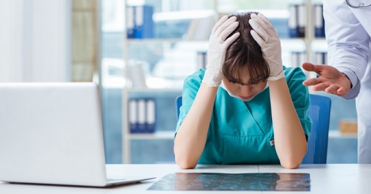 medical professional looking down while being chewed out by supervisor